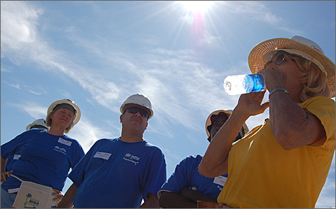 Construction photography - Habitat Tucson crew leader drinks water on a hot day